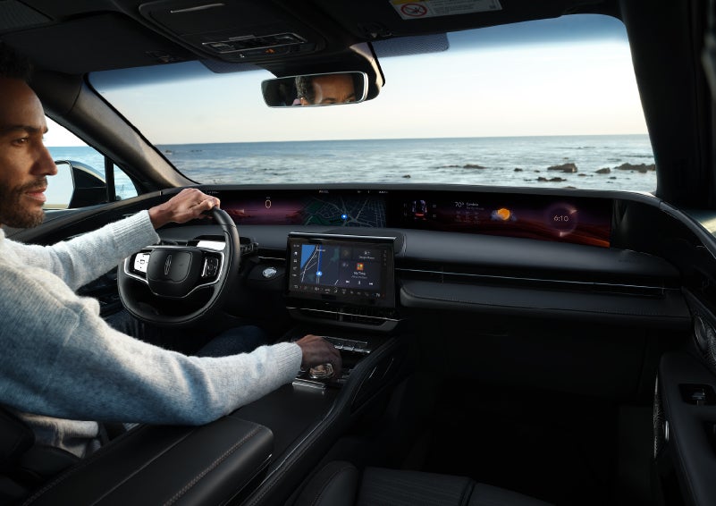 A driver of a parked 2024 Lincoln Nautilus® SUV takes a relaxing moment at a seaside overlook while inside his Nautilus. | Sheehy Lincoln of Gaithersburg in Gaithersburg MD
